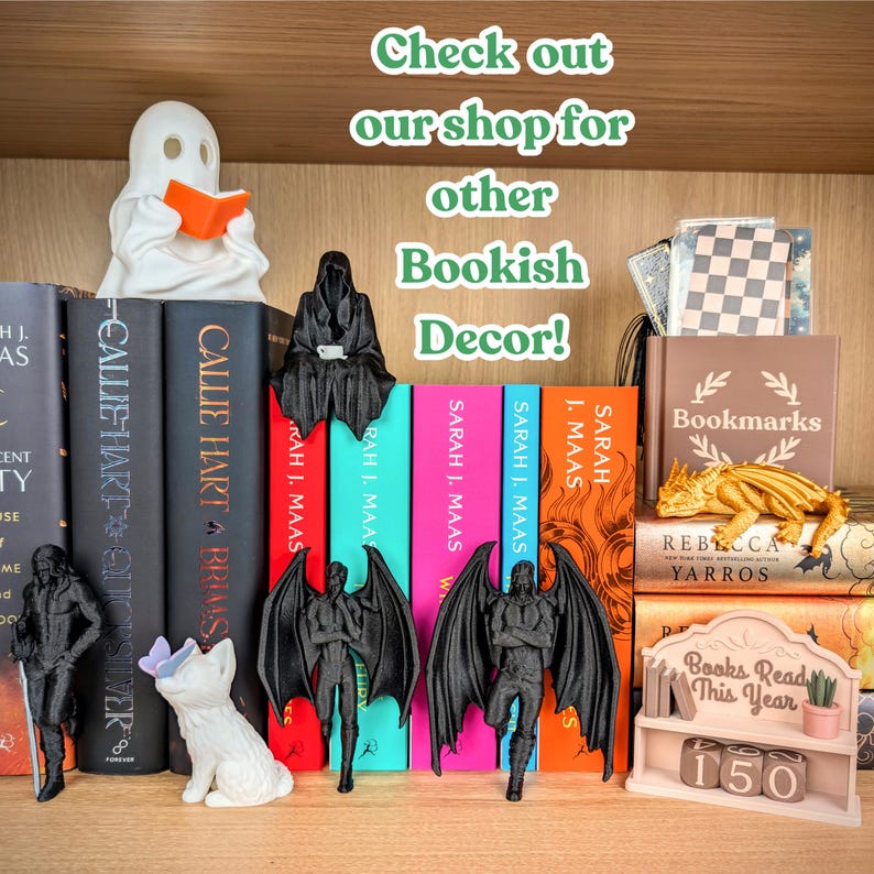 Puede incluir: Una colecci&oacute;n de art&iacute;culos de decoraci&oacute;n literaria impresos en 3D, incluyendo un fantasma blanco leyendo un libro naranja, figuras aladas negras, un gato blanco con una mariposa morada, un drag&oacute;n dorado y un estante rosa con el texto Books Read This Year 150.