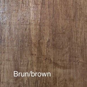 May include: Close-up of a brown wooden surface with vertical grain. The surface has a glossy finish and a natural wood grain pattern. The text "Brun/brown" is displayed in white at the bottom.