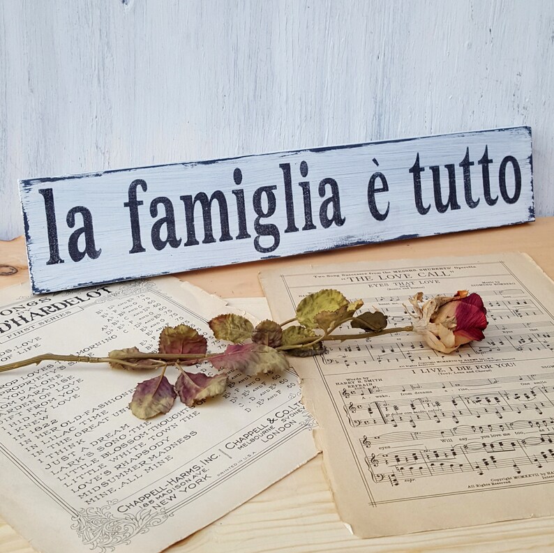 La Famiglia e Tutto, Italian Family Sign white with black lettering. vintage sheet music with rose sitting on top.