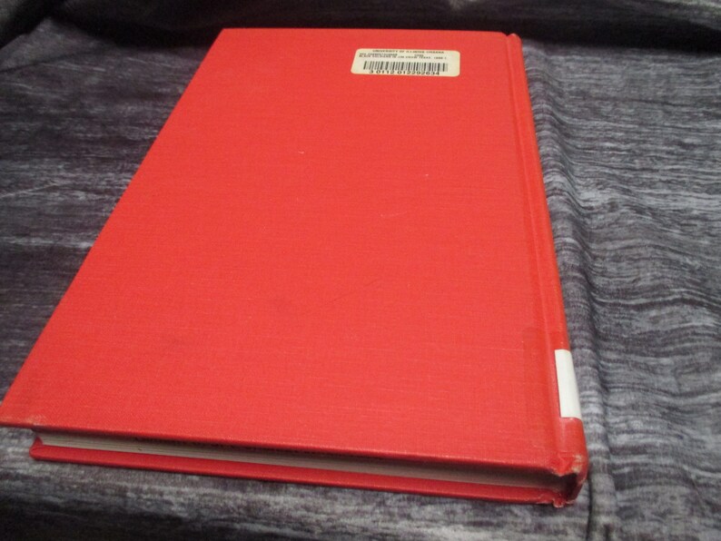 May include: A red hardcover book with a barcode sticker on the back cover.