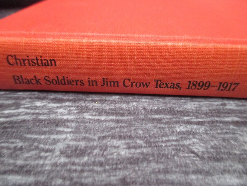 May include: A red book with the title "Christian Black Soldiers in Jim Crow Texas, 1899-1917" on the spine.