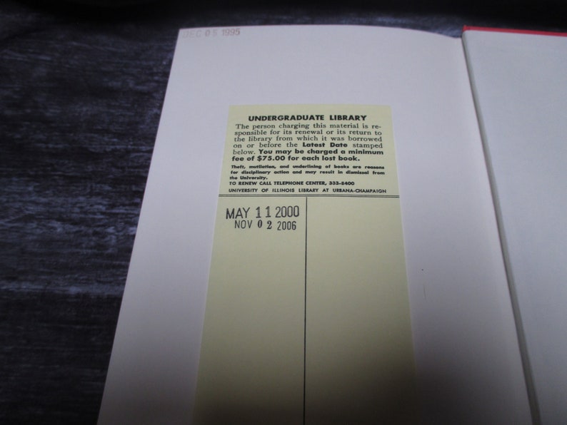May include: A yellow library card with black text. The text reads "UNDERGRADUATE LIBRARY" and includes instructions for returning library materials. The card also includes the dates "MAY 11 2000" and "NOV 02 2006".