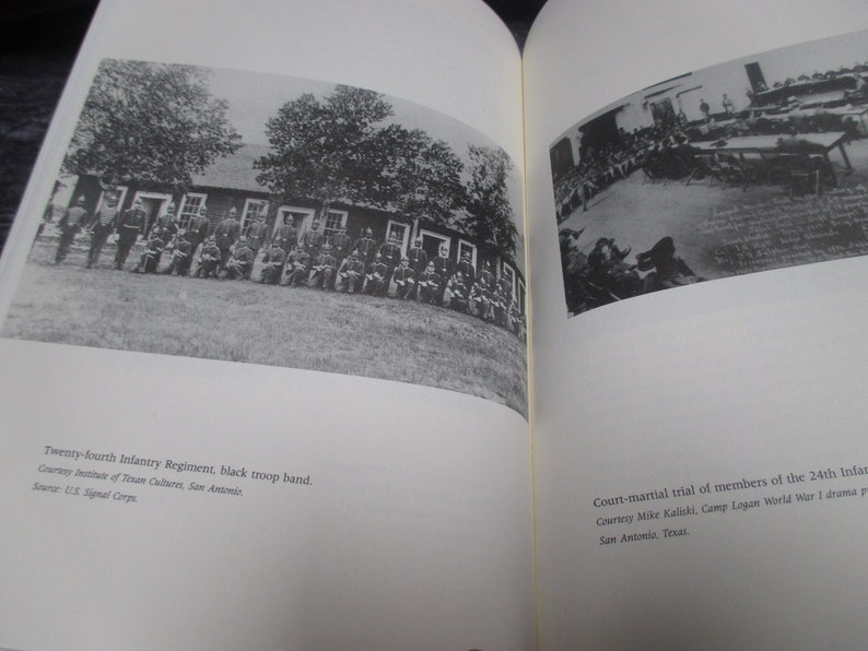 May include: A black and white photograph of a group of men in military uniform standing in front of a building. The men are arranged in rows and are all looking at the camera. The building is a simple wooden structure with a few windows. The photograph is titled "Twenty-fourth Infantry Regiment, black troop band." and is credited to the US Signal Corps.