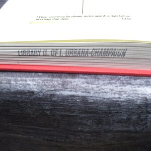 May include: Close-up of the spine of a book with the text "LIBRARY U. OF I. URBANA CHAMPAIGN" printed in black on a white background.