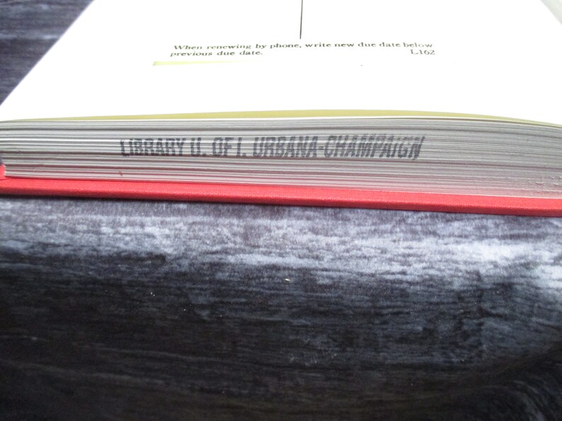 May include: Close-up of the spine of a book with the text "LIBRARY U. OF I. URBANA CHAMPAIGN" printed in black on a white background.