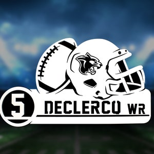 Puede incluir: Casco de fútbol americano blanco y negro con un logotipo de pantera negra en el lateral. El casco está sobre un fondo blanco con un círculo negro que contiene el número 5 y el texto "DECLERCQ WR".