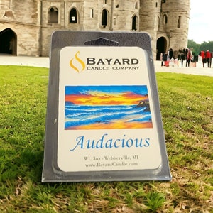 May include: A black and white candle label with a sunset over the ocean scene. The label reads "Audacious" and "Bayard Candle Company". The text also says "Wt. 3oz - Webberville, MI" and "www.BayardCandle.com".