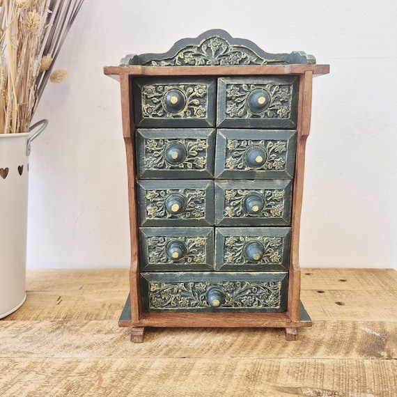 A tiny handcrafted wooden chest with mini drawers — a jewellery organiser that looks like it belongs in a Victorian curiosity cabinet.