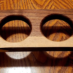 Pu&ograve; includere: Un vassoio in legno con quattro tagli circolari, perfetto per contenere bicchieri o tazze. Il vassoio &egrave; realizzato in due tipi di legno, uno chiaro e uno scuro, e ha accenti metallici decorativi alle estremit&agrave;.