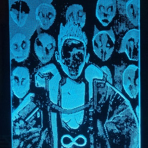 May include: A blue LED night light with a 3D printed image of a person with an infinity symbol on their chest. The image is surrounded by smaller images of faces.