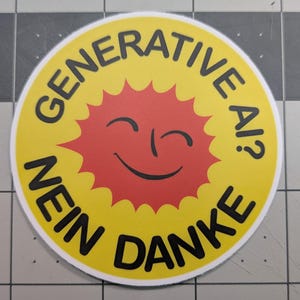 May include: A round sticker with a yellow background and black text that reads "GENERATIVE AI!? NEIN DANKE". The center features a red sun with a smiling face.