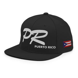 May include: Black baseball cap with a flat peak. The cap has white embroidered letters "PR" and the words "Puerto Rico" in white. A small Puerto Rican flag is embroidered on the side.