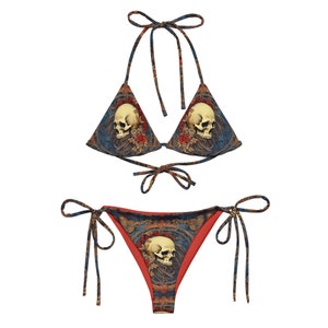 May include: A blue and red bikini with a skull and floral print. The top is a triangle style with adjustable straps and ties at the back. The bottom is a cheeky style with ties on the sides.