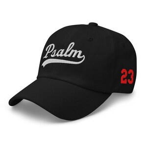 Peut inclure: Casquette de baseball noire avec le mot "Psalm" brodé en blanc sur le devant. Le chiffre "23" est affiché en rouge sur le côté. La casquette a une visière incurvée et une conception classique.