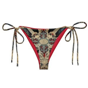 Pode incluir: Uma parte de baixo de biquíni com padrão vermelho e preto com um design floral e laços nas laterais.