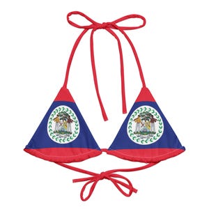 May include: A red, white, and blue bikini top featuring the Belize coat of arms. The triangle-shaped cups have a blue background with the coat of arms in the center, and a red border. The straps are red and tie at the neck and back.