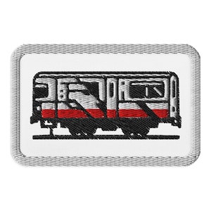 Peut inclure: Un patch brodé représentant un train avec des roues noires et une carrosserie grise. Le train est sur une voie noire, avec un design blanc et rouge.