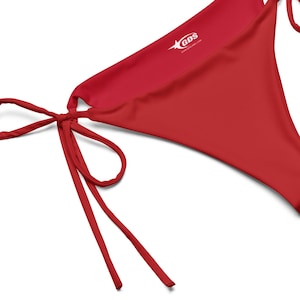 Puede incluir: Braga de bikini roja con lazos ajustables. La braga de bikini tiene un pequeño logotipo que dice "GDS" con una estrella.