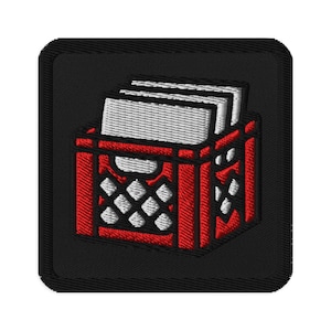 May include: Embroidered patch featuring a red crate filled with white books. The crate has a diamond pattern and is outlined in red. The patch is on a black background with a black border. The design is detailed and appears to be machine-embroidered.