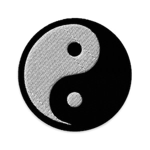 Pode incluir: Um patch circular Yin Yang em preto e branco. A parte branca é bordada com um padrão texturizado, e a parte preta é sólida. O patch tem uma borda preta e está sobre um fundo branco.