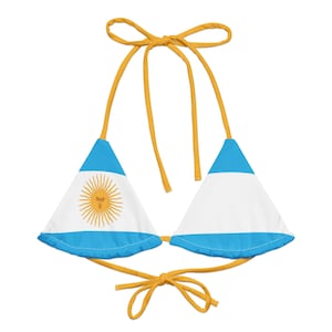 May include: A blue and white bikini top with a yellow sun and face design. The bikini top has yellow straps.