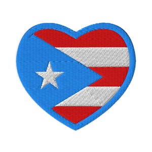 May include: Embroidered heart-shaped patch featuring the flag of Puerto Rico. The design includes a blue field with a white star, and red and white stripes. The patch is outlined in blue.