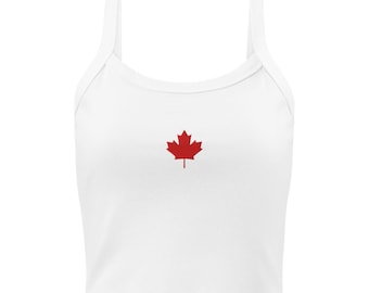 May include: White crop top with thin straps and a red maple leaf emblem. The top is a casual style, suitable for warm weather. The maple leaf is centered on the chest.