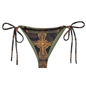 Puede incluir: Braga de bikini verde y negra con un patrón de cruz dorada. La braga de bikini tiene lazos ajustables a cada lado.