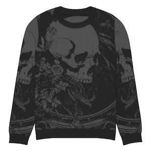 Op de afbeelding: Een zwarte longsleeve trui met een grijs schedel- en bloemenpatroon.