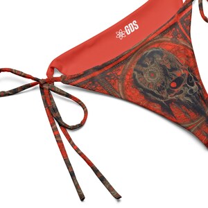 Puede incluir: Braga de bikini de estampado rojo y negro con un diseño de calavera y el texto "GDS" en el interior de la tela.