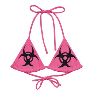 Puede incluir: Parte superior de bikini rosa con estampado de símbolo de riesgo biológico negro.