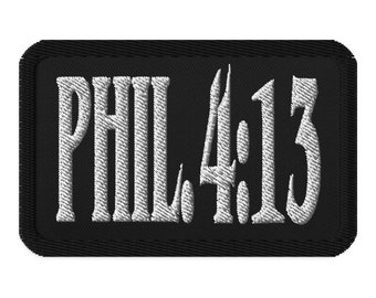 以下が含まれることがあります： 黒い刺繍パッチに白い文字で「PHIL 4:13」と書いてあります。