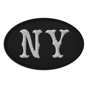 May include: Black oval patch with white embroidered letters "NY" in a stylised font.