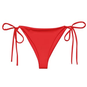May include: A vibrant red bikini bottom with tie sides. The bottoms have a classic triangle shape and are made of a smooth, solid-colored fabric. The ties are long and allow for an adjustable fit.