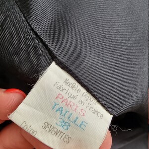 May include: A white tag with black text that reads "Mod&egrave;le d&eacute;pos&eacute; Fabriqu&eacute; en France Paris Taille 38 Coton SEVENTIES".