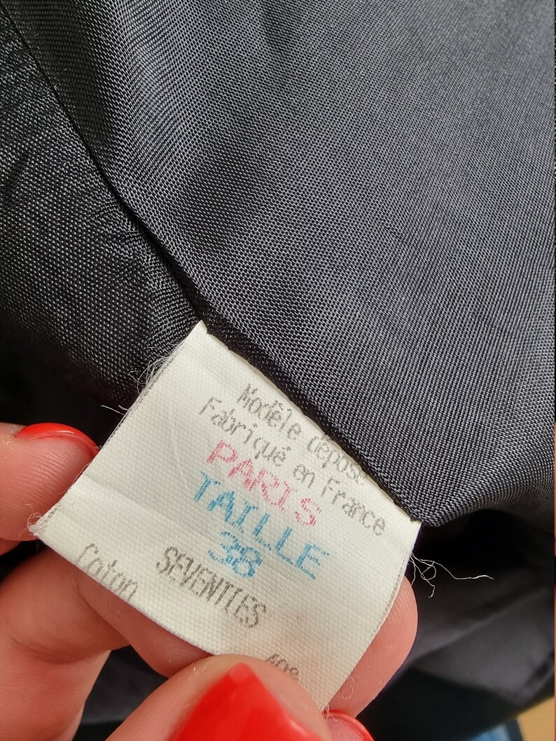 May include: A white tag with black text that reads "Mod&egrave;le d&eacute;pos&eacute; Fabriqu&eacute; en France Paris Taille 38 Coton SEVENTIES".