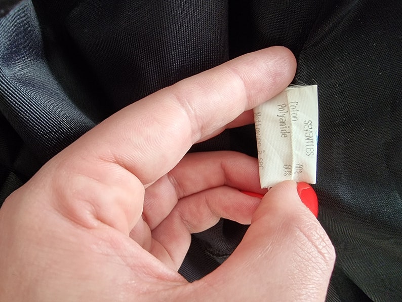May include: A white fabric label with the text "SEVENTIES" printed in black. Below the text, it reads "Cotton 48% Polyamide 52%".