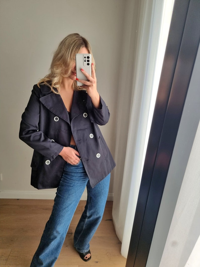 May include: A navy blue double-breasted jacket with silver buttons and a slightly oversized fit.