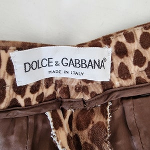 Puede incluir: Una tela de estampado de leopardo marr&oacute;n y beige con una etiqueta blanca que dice "DOLCE & GABBANA&reg; MADE IN ITALY".