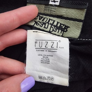 May include: White tag with black text that reads "FUZZI" and "S. GIOVANNI IN MARIGNANO SPA" with the text "100% POLIAMMIDE NYLON POLYAMID POLYAMIDE POLIAMIDA" below. The tag also has a care label with symbols for washing, ironing, and dry cleaning.