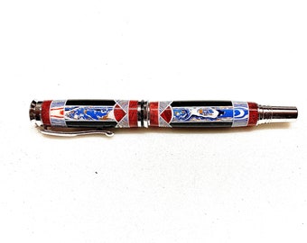 May include: A black and silver pen with a red, white and blue patterned design. The pen has a silver clip and a silver cap.