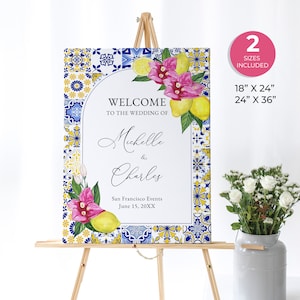 Puede incluir: Un cartel de bienvenida con un patrón de azulejos azules y amarillos, limones y flores rosas. El cartel dice "Bienvenido a la boda de Michelle & Charles" e incluye la fecha "15 de junio de 20XX". El cartel está disponible en dos tamaños: 46 cm x 61 cm y 61 cm x 91 cm.