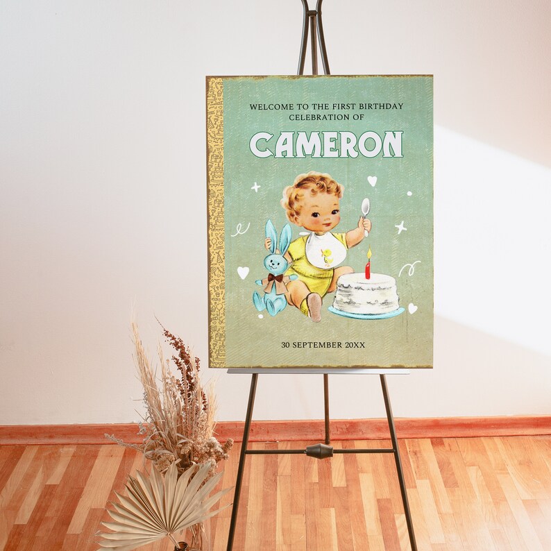 May include: A vintage-style first birthday party sign with a green background and gold trim. The sign features a cartoon illustration of a baby boy holding a toy bunny and a birthday cake with a single candle. The text reads "Welcome to the first birthday celebration of Cameron 30 September 20XX".
