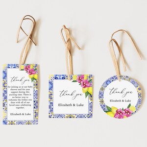 Puede incluir: Tres etiquetas de agradecimiento para baby shower con cordón de cuero. Las etiquetas tienen un borde de diseño de azulejos azules y amarillos, detalles florales y las palabras "thank you" y "Elizabeth & Luke".