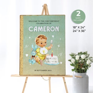 May include: A vintage-style sign with a blue background and gold trim. It says "Welcome to the first birthday celebration of Cameron" and features a cartoon baby boy with a bunny and a birthday cake. The date "30 September 20XX" is printed at the bottom.