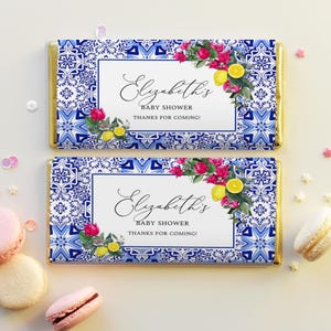 May include: Two blue and white patterned chocolate bar wrappers with gold trim. The wrappers feature a floral design with lemons and the text "Elizabeth's Baby Shower Thanks for Coming!"