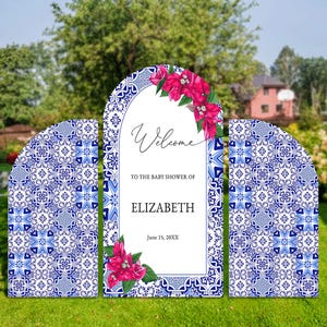 May include: Three blue and white tiled archway baby shower welcome signs with pink flowers and the text "Welcome to the baby shower of Elizabeth June 15, 20XX"