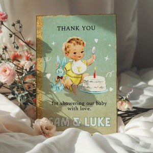 May include: A vintage-style thank you card with a blue and yellow illustration of a baby boy holding a spoon and a blue bunny. The card says "Thank You for showering our baby with love. Sam & Luke".