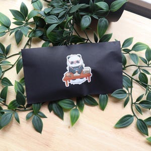 May include: A black and white panda wearing sunglasses and a blue shirt sits at a desk with a stack of papers and a cup of coffee. The sticker says "papercraftpanda".