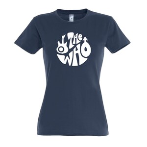 May include: A navy blue t-shirt with a white circular logo of the band "The Who". The logo includes a guitar and other symbols. The text "The Who" is in a stylized font. The t-shirt has short sleeves and a crew neck.